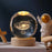 Glass ball with galaxy design on a wooden base, surrounded by decorative items.