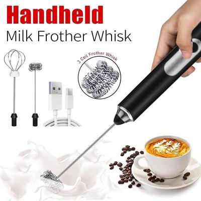 Handheld milk frother whisk with USB cable, hand holding it, and a cup of coffee with foam.